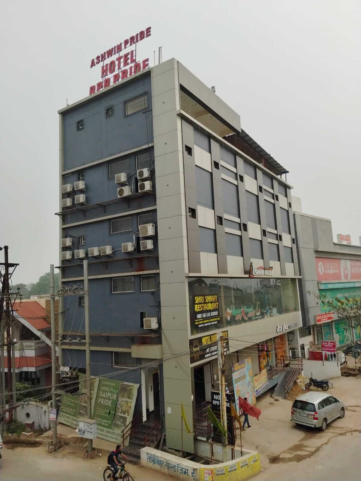 A multi-story building with signage for Ashwin Pride Hotel and RDR Pride.