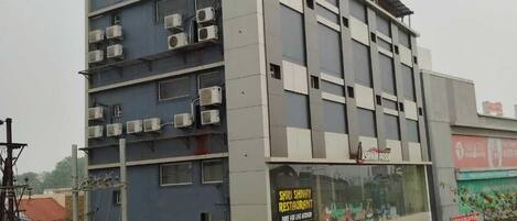 A multi-story building with signage for Ashwin Pride Hotel and RDR Pride.