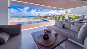 Et moderne udendørs opholdsområde med udsigt til havet og en swimmingpool.