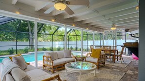 A covered outdoor patio with a pool, wicker furniture, and ceiling fans. - 2BR Retreat - Private Pool Near Siesta Key (Sarasota)