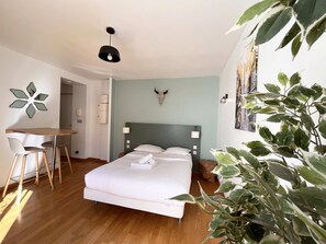 A bedroom with a bed, a desk, and a chair.