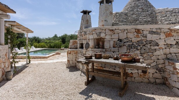 A stone building with a pool, outdoor seating, and cooking equipment. - Villa Borghetto Formica (Ostuni)