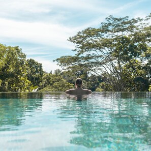 A person in a clear pool with a tropical background. - Ayawana Private Villa by ARM Hospitality (Tegallalang)