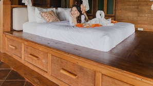 A wooden cabin-style bedroom with a four-poster canopy bed, a wooden nightstand, and a large window. - Ayawana Private Villa by ARM Hospitality (Tegallalang)