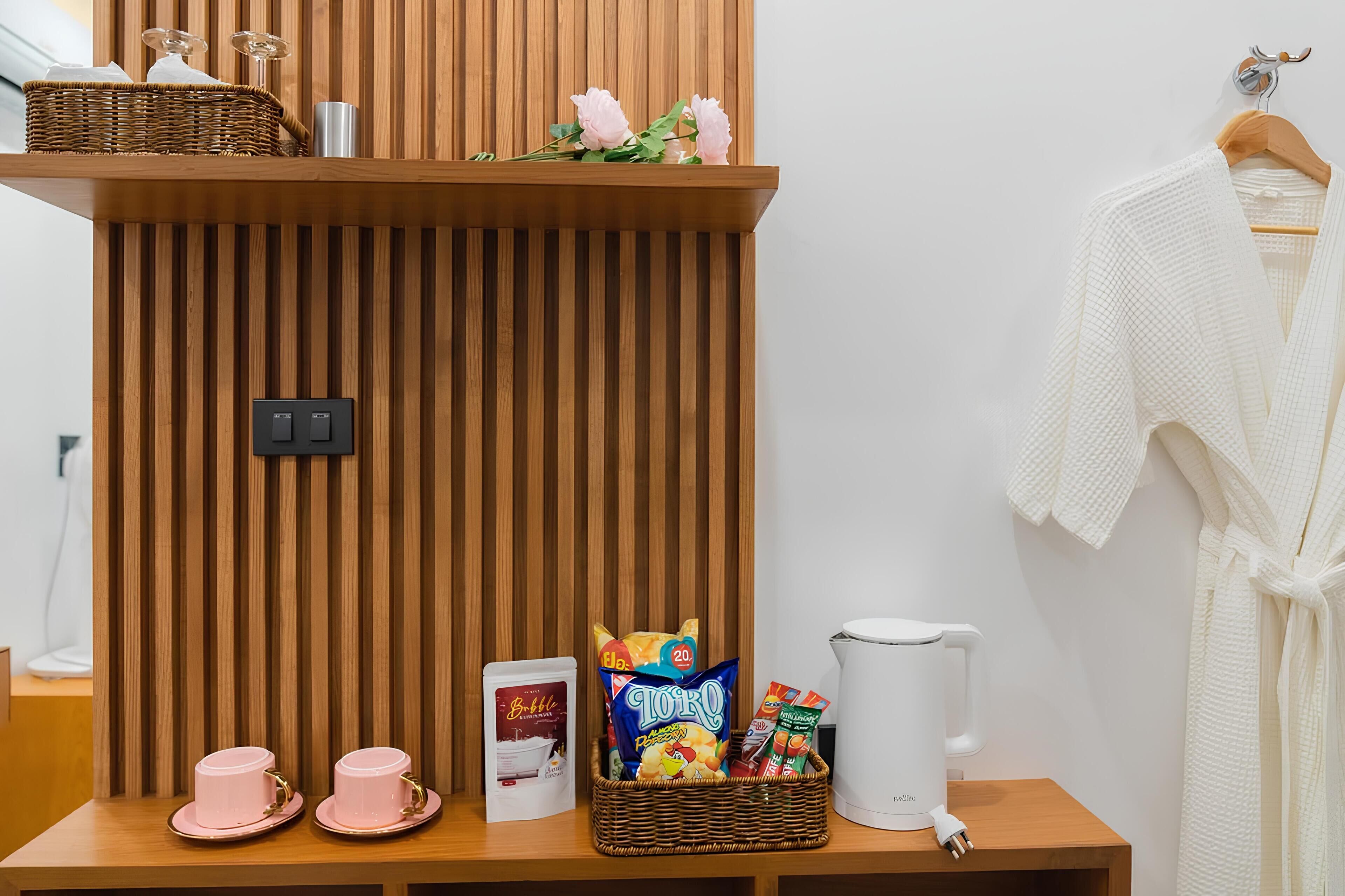 A wooden shelf with a basket, a coffee maker, and a basket of snacks.