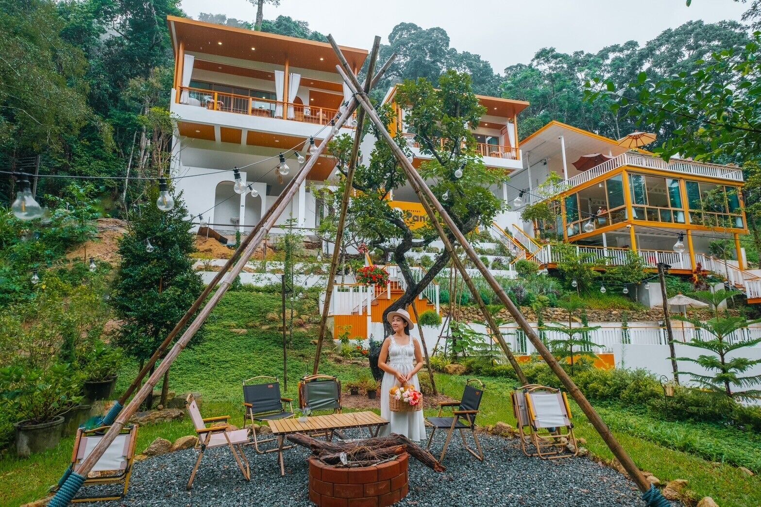 A modern resort with multiple levels, outdoor seating, and lush greenery.