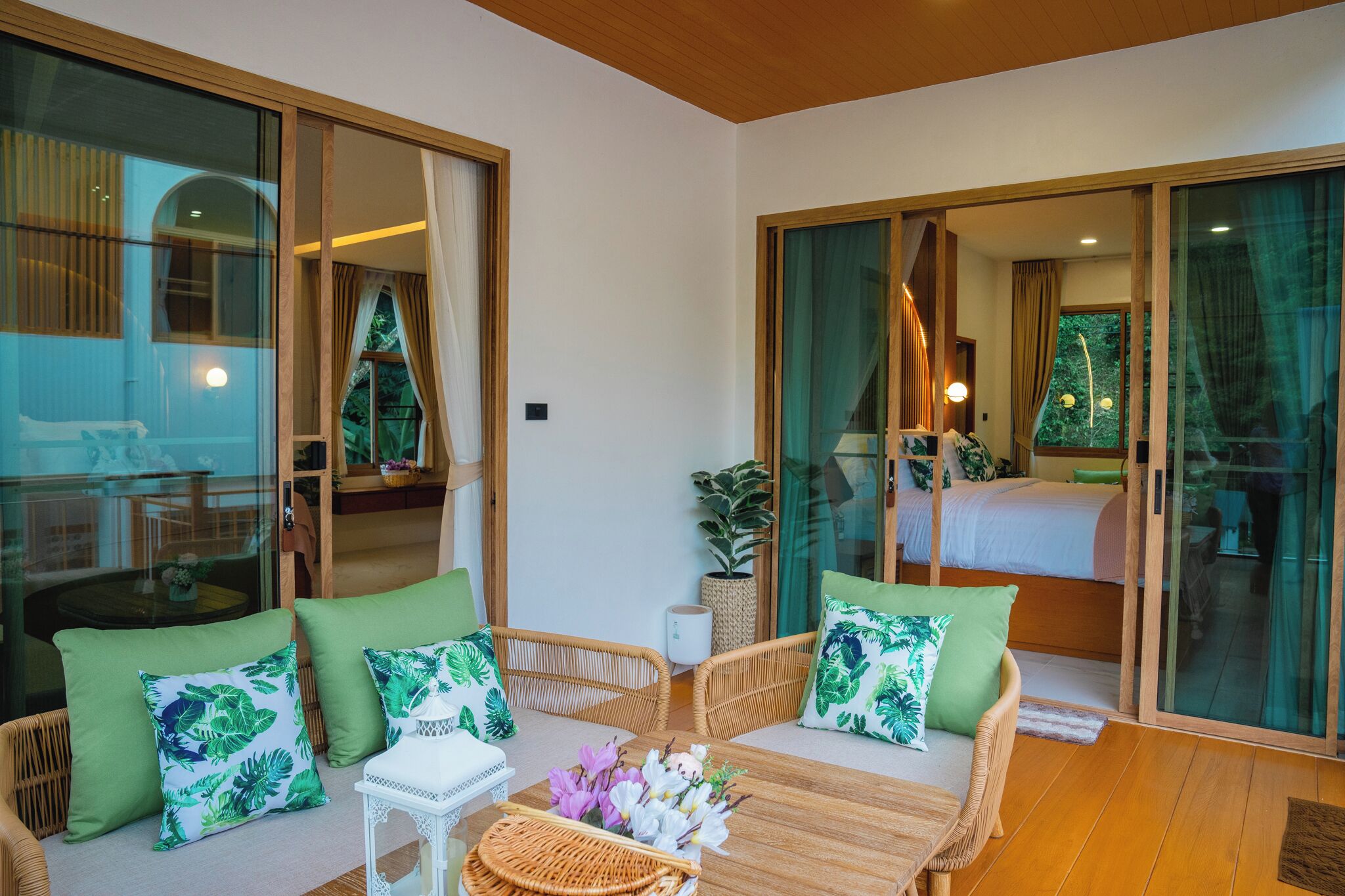 A room with wicker furniture, a bed, and a sliding glass door leading to a balcony.