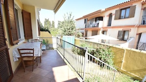 A balcony with a table and chairs, a railing, and a view of neighboring buildings. - APP.LIBECCIO - Appartamento LIBECCIO (Pula)