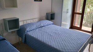 A bedroom with a bed, two bedside tables, a wardrobe, and a window with a view. - Casa Eden Roch - Villa Sole (Domus de Maria)