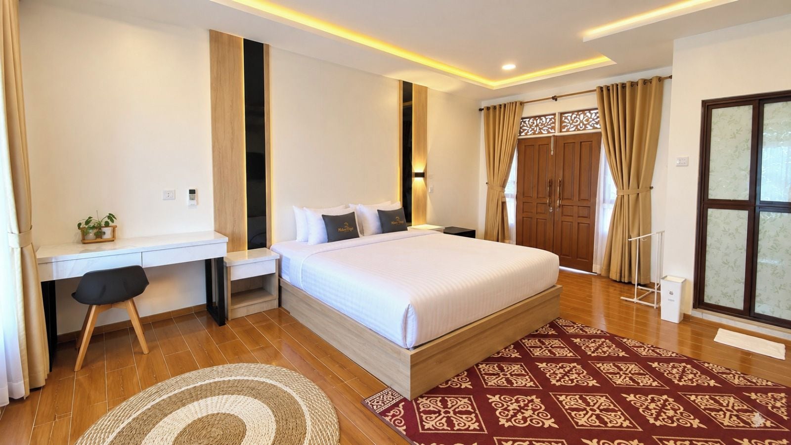 Ein modernes Hotelzimmer mit einem großen Bett, einem Schreibtisch und einem Kleiderschrank.