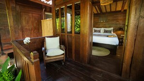 Une cabane en bois avec un lit, une chaise et une petite table.