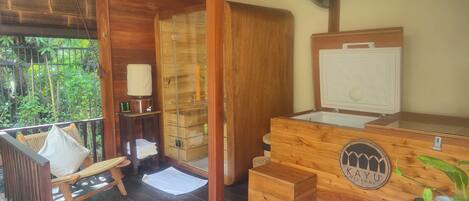 Una cabaña de madera con un banco de madera, una mesita con una toalla y un aparador de madera.