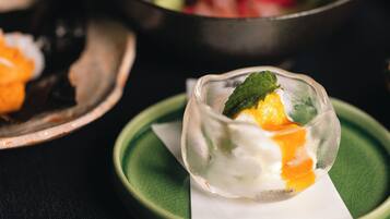 Un postre en un bol de vidrio sobre un plato verde con una servilleta debajo.