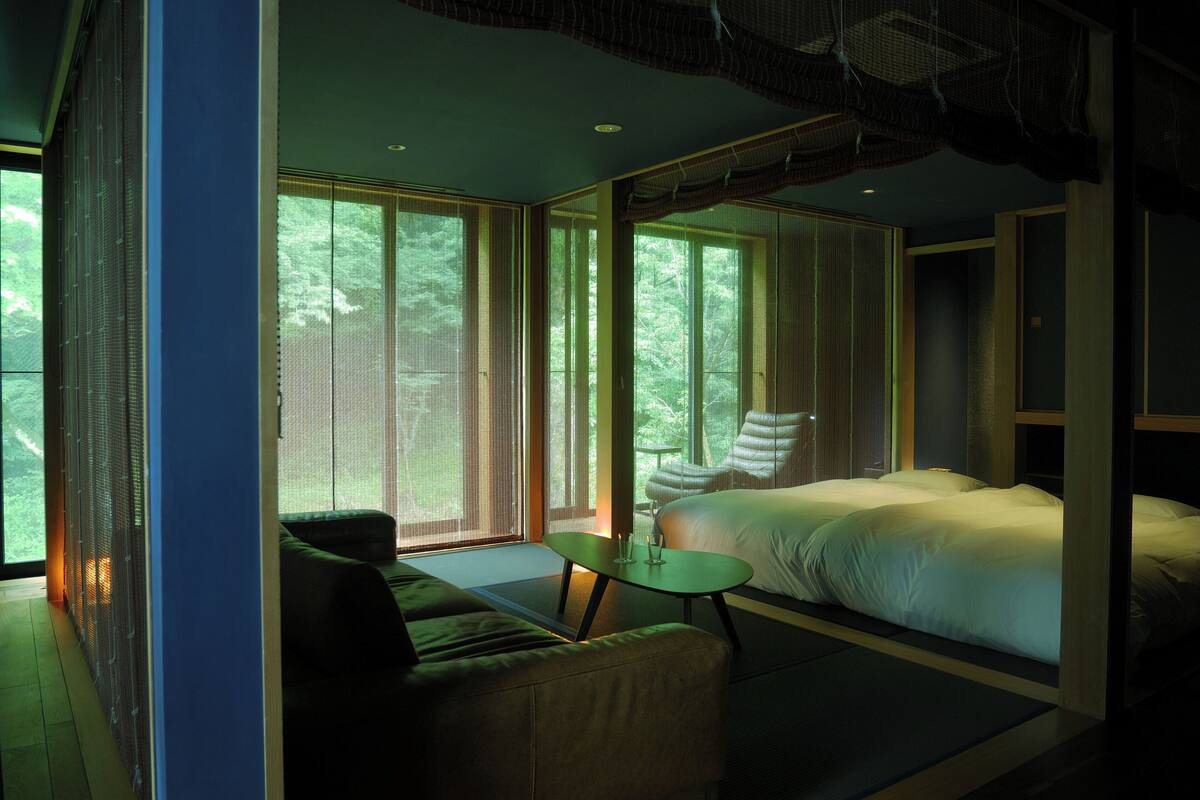 Une chambre moderne avec un grand lit, une petite table et un canapé.