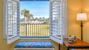 A room with a bench, a table with a lamp, and a window with open shutters. - Stunning Ocean Views, Beachfront Pool, Heated Indoor Pool, Hot Tub, Family Condo, Tennis, Gym, Sauna (St. Augustine)