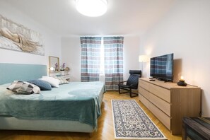 Une chambre à coucher avec un lit, une télévision, un bureau et une chaise.