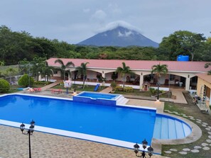 A hotel with a swimming pool, outdoor seating, and a view of a mountain. - Hotel Campestre Bella Vista (Moyagalpa)