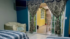 A room with two beds, a sofa, and a view through a doorway to a balcony. - House Green (Ecatepec de Morelos)