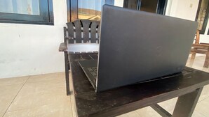 Ein Laptop auf einem Tisch, im Hintergrund ein Stuhl.