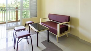 A room with a sofa, two chairs, a table, and a window with blinds. - OYO Life 93399 Kos Batulayar (Senggigi)