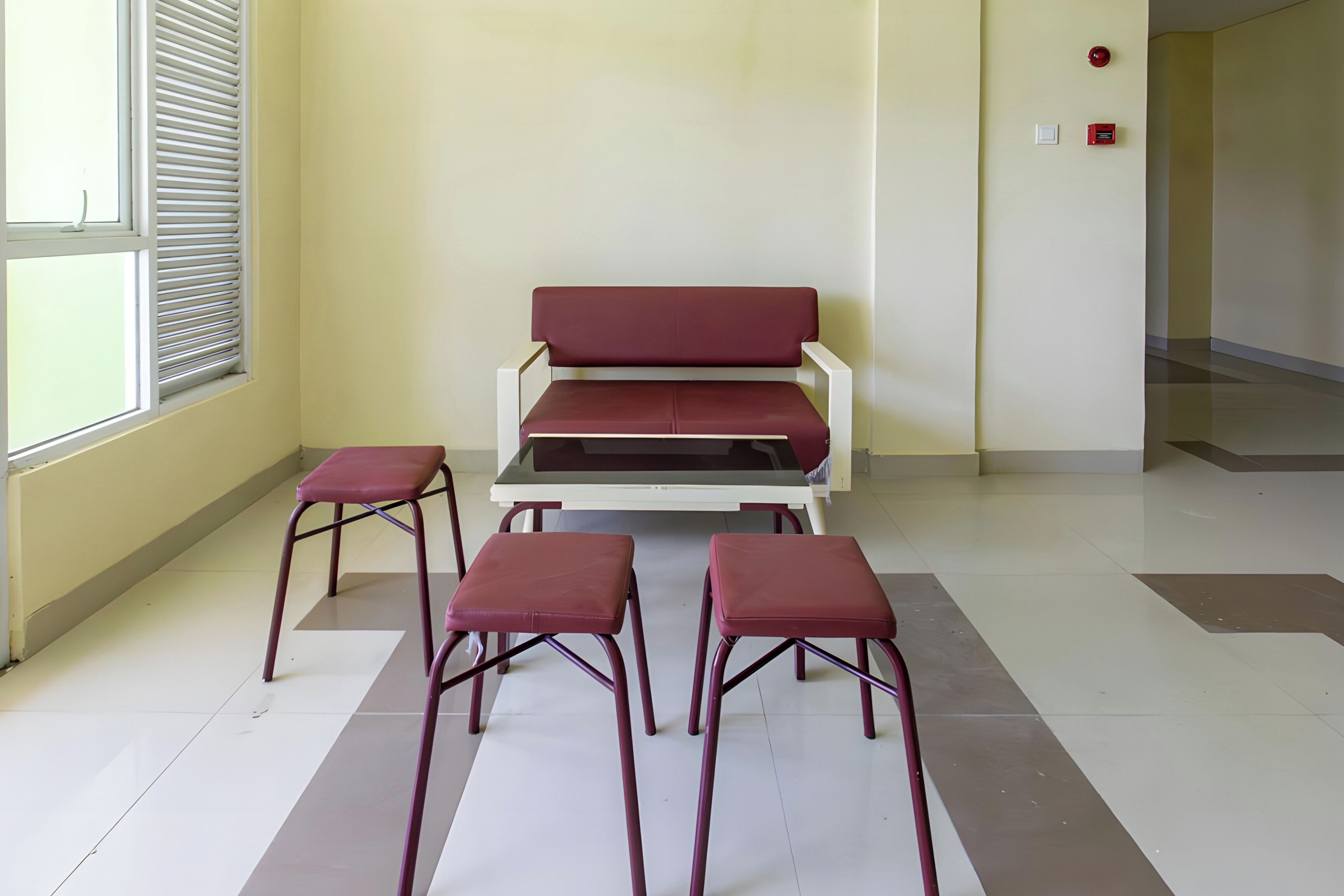 A waiting area with a bench, two stools, and a table.