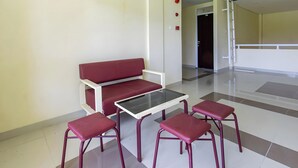A seating area with a sofa and four chairs, a glass-top table, and a tiled floor. - OYO Life 93399 Kos Batulayar (Senggigi)