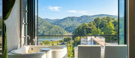 A balcony with a view of a mountainous landscape and a body of water.