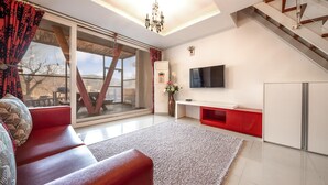 Una sala de estar moderna con un sofá, un televisor, un mueble rojo y una escalera.