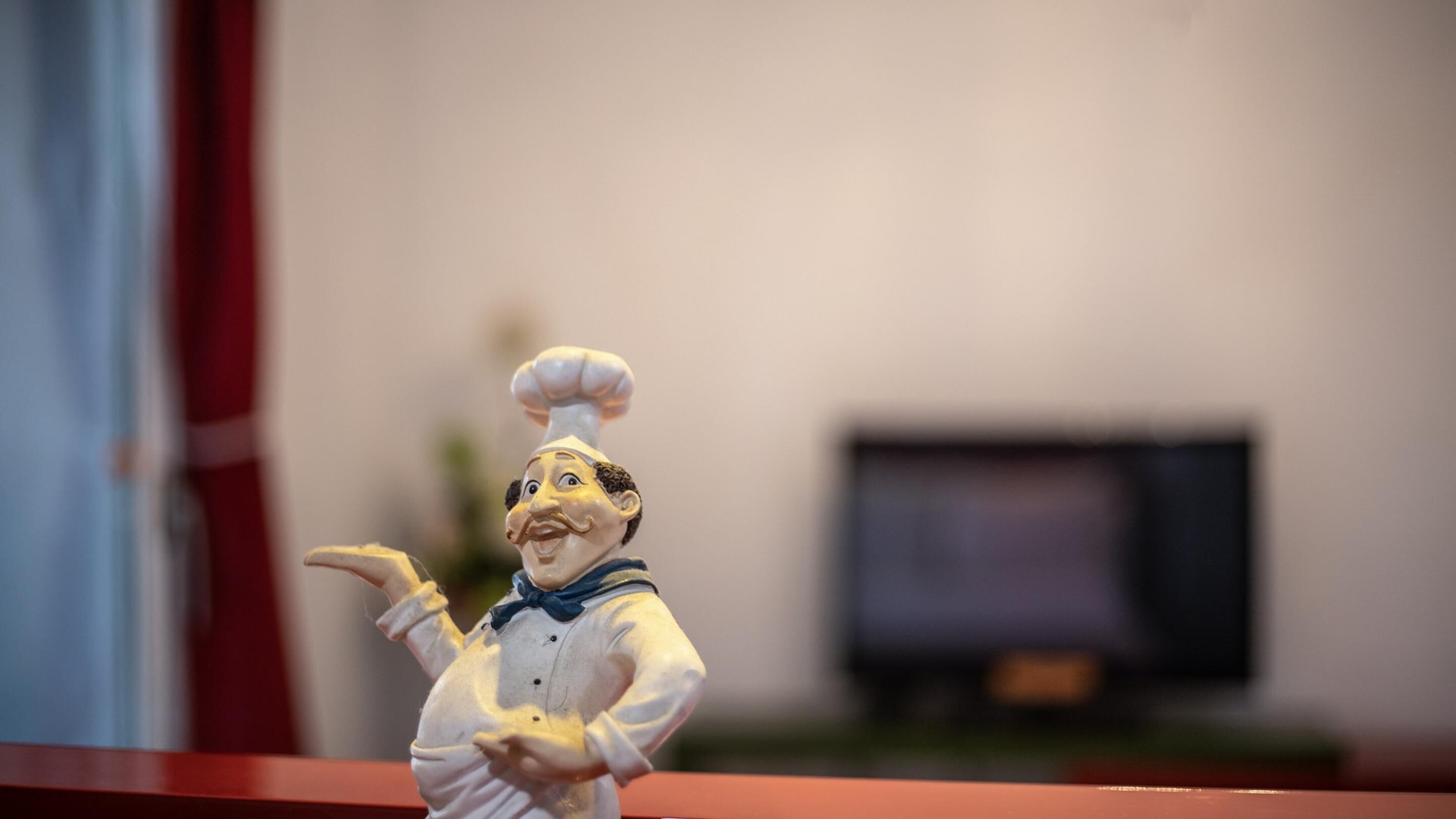 Una figurita de un chef señalando hacia la derecha.