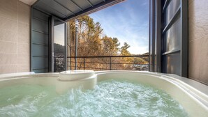 Un jacuzzi con vista a árboles y colinas.