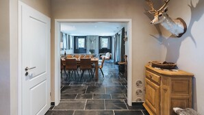 A hallway leading to a dining area with a mounted deer head on the wall. - Villa in Durbuy near Golf Course (Durbuy)