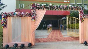 Una entrada con alfombra roja y decoración floral.