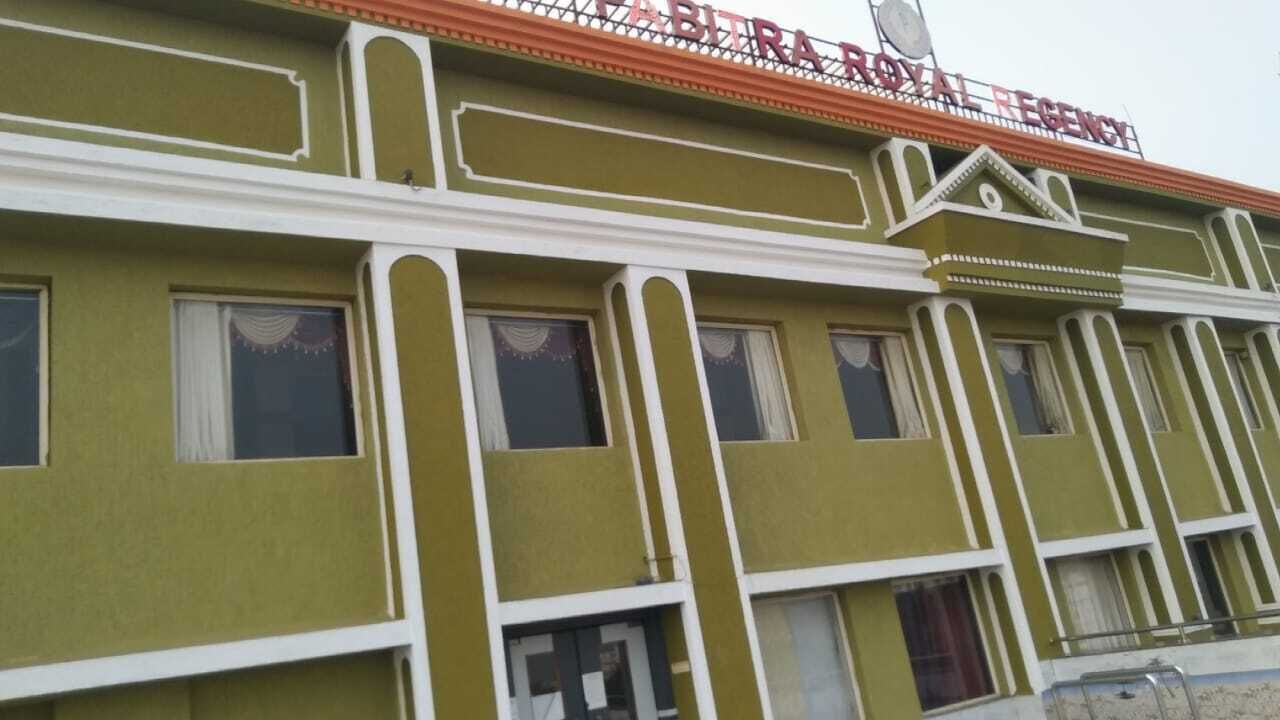 A building with a green facade and white trim, featuring a sign that reads "ROYAL REGENCY."