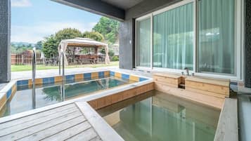 Una piscina con un muelle de madera, una zona de estar techada y un ventanal grande.