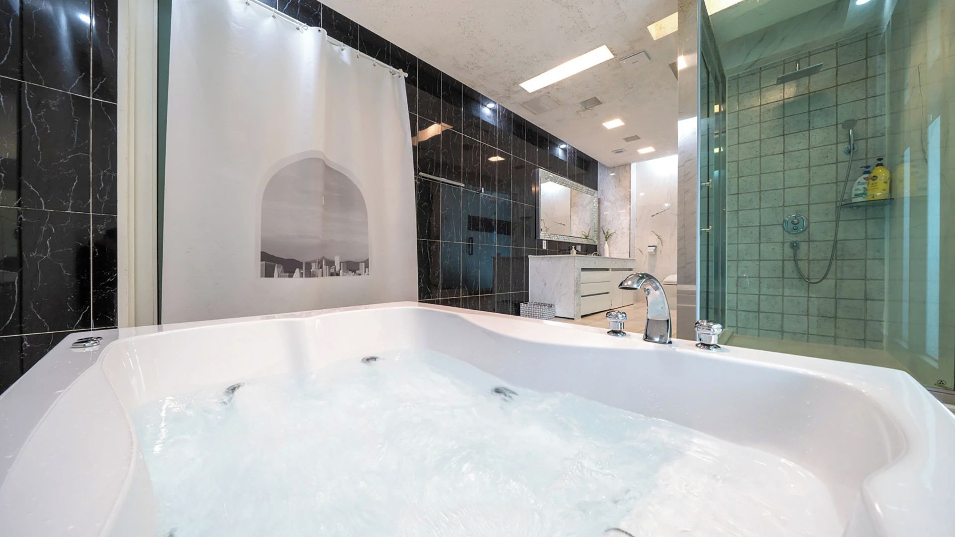 Un baño moderno con una bañera grande, zona de ducha y tocador con espejo.