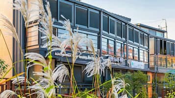 Een modern gebouw met grote ramen en een bordje met de tekst 'Sunchonman Season House'.