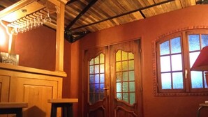 Een kamer met houten deuren, een bar en een raam met uitzicht.