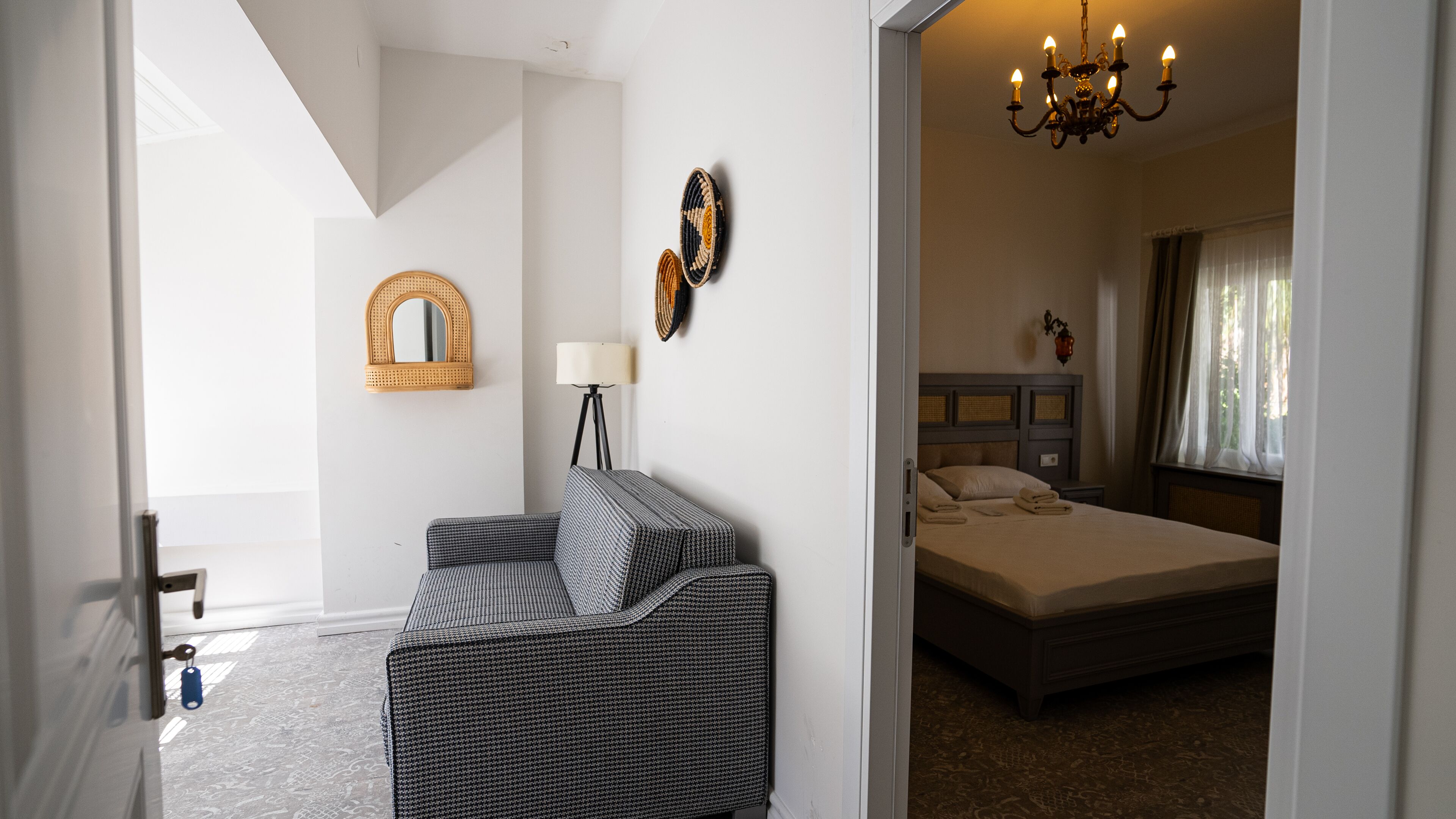 A bedroom with a bed, a bedside table, a lamp, and a chair.