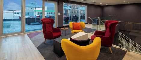 A modern lounge area with seating and a view of the cityscape.