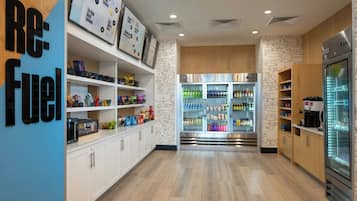 A modern kitchen with white cabinetry, a central island, and a refrigerator.