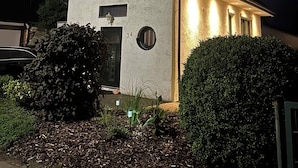 Ein zweistöckiges Haus mit dunklem Dach, einer Haustür und der Hausnummer 34 an der Wand.
