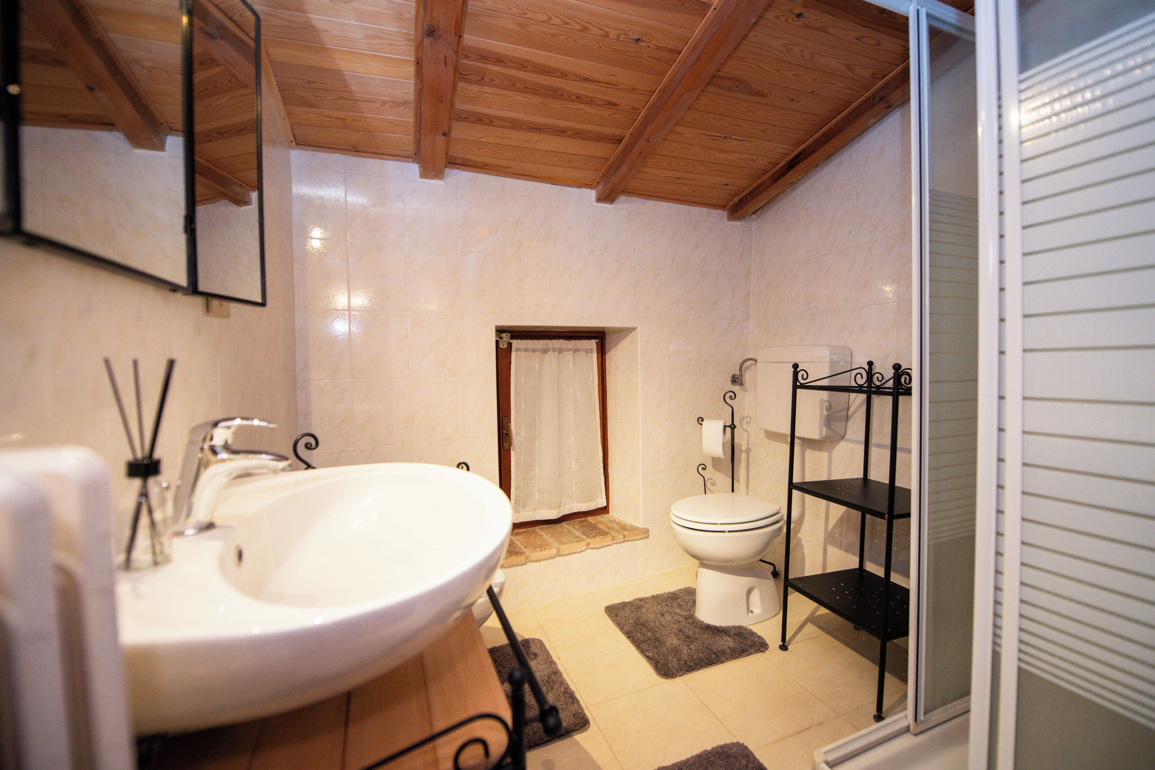 Een badkamer met een wastafel, toilet en planken.