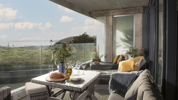 A balcony with a table set for dining, wicker furniture, and a view of the sea. - Ocean's Eleven, The Liner - Sea view - footsteps from the beach - Free parking (Falmouth)