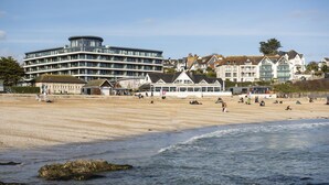 A beach with a modern building and traditional houses in the background. - Ocean's Eleven, The Liner - Sea view - footsteps from the beach - Free parking (Falmouth)
