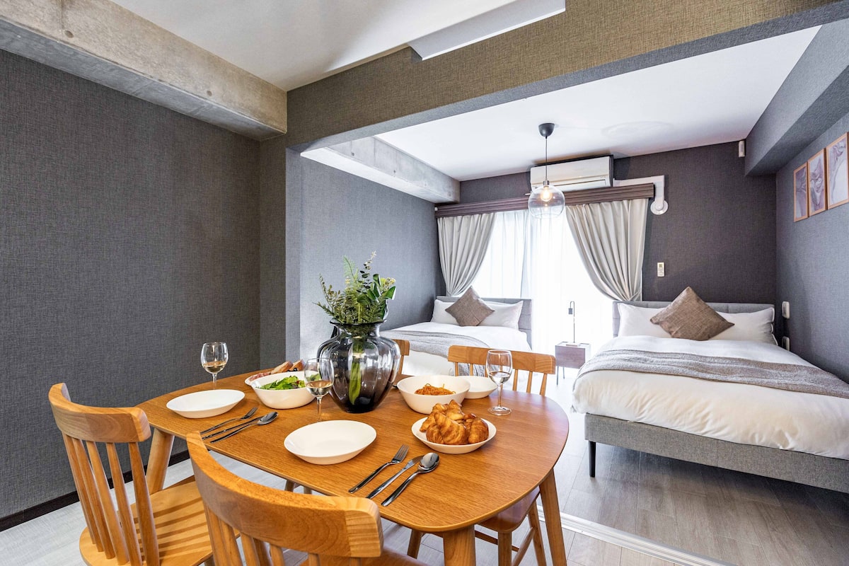 Une chambre d’hôtel moderne dotée d’un coin repas, d’un lit et d’une grande fenêtre avec des rideaux.