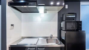 A modern kitchen with stainless steel appliances, a microwave, and a built-in oven. - MELL-THEATER RESORT (Osaka)