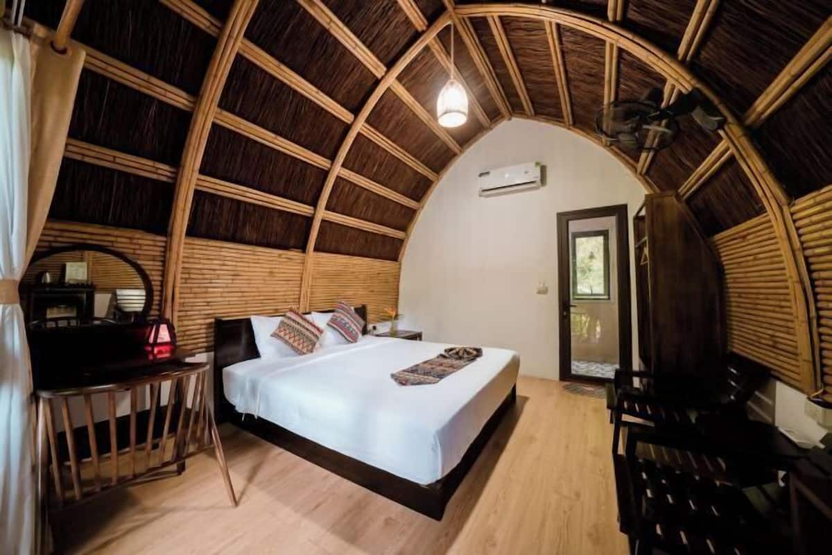 Una habitación circular y acogedora con una cama, una mesita y una silla.
