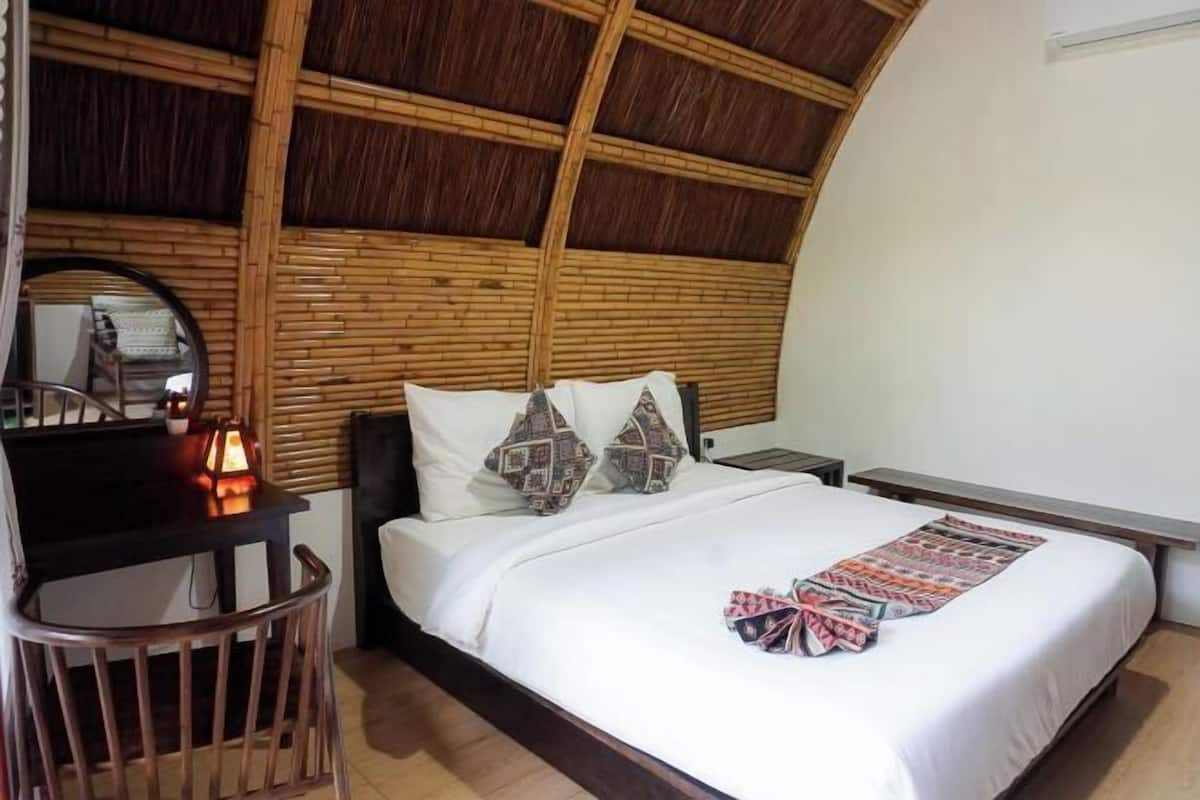 Una habitación con cama, escritorio, silla y espejo.