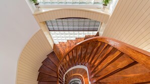 A wooden spiral staircase with a glass enclosure at the top.