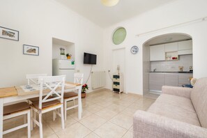 Un espace de vie compact comprenant un coin repas, une kitchenette et un canapé.